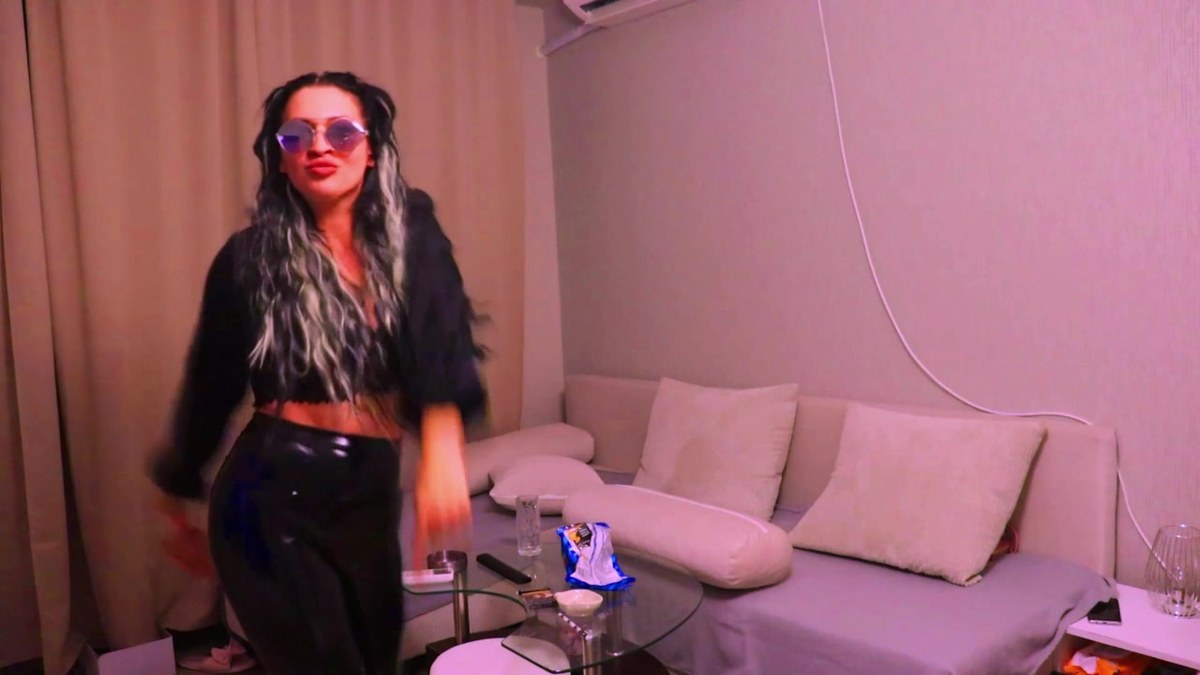 Yo celebrating with her found rocker sunglasses on, dancing in the living room